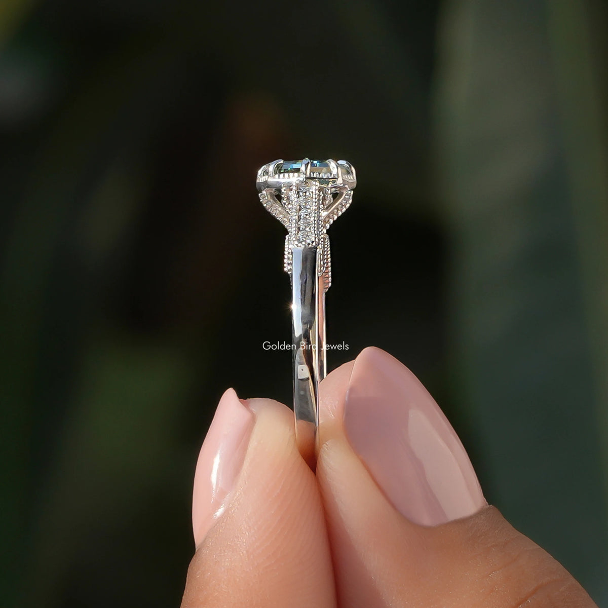Side View of Moissanite Green Octagon Accent Ring In two fingers