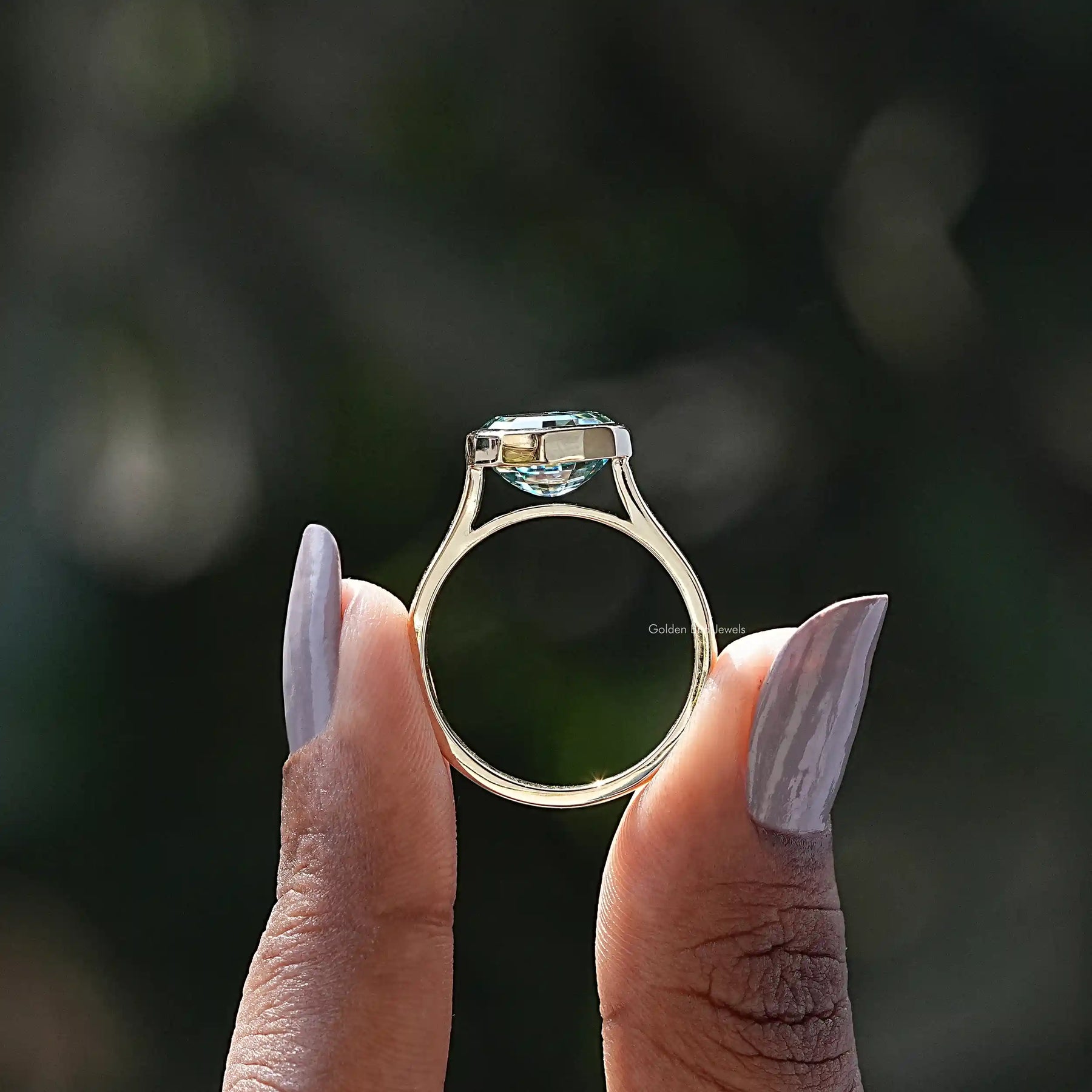 Back View of Blue Green Oval Cut Moissanite Ring In two fingers