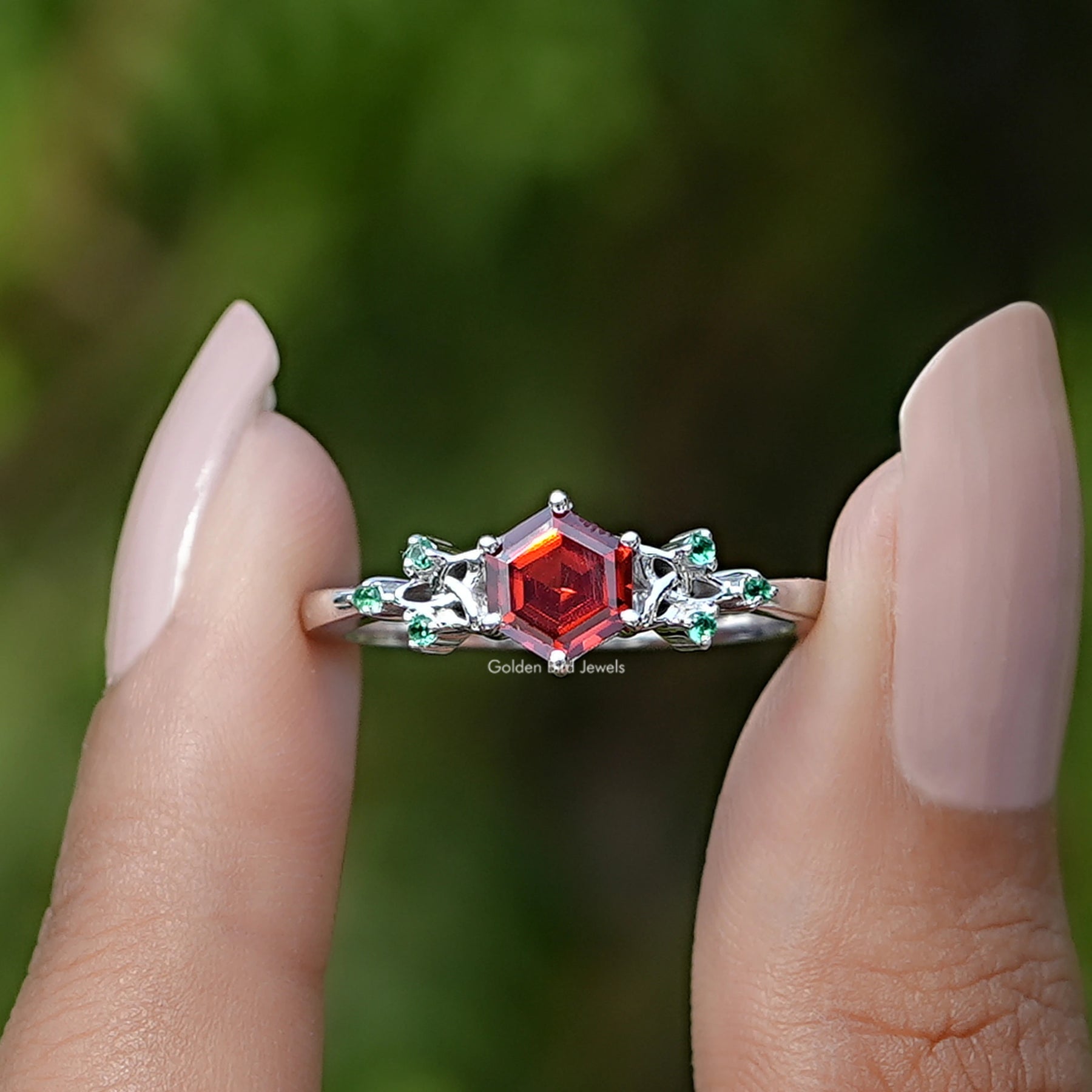 Front View of Sunstone Hexagon Cut Gemstone Ring In two Fingers