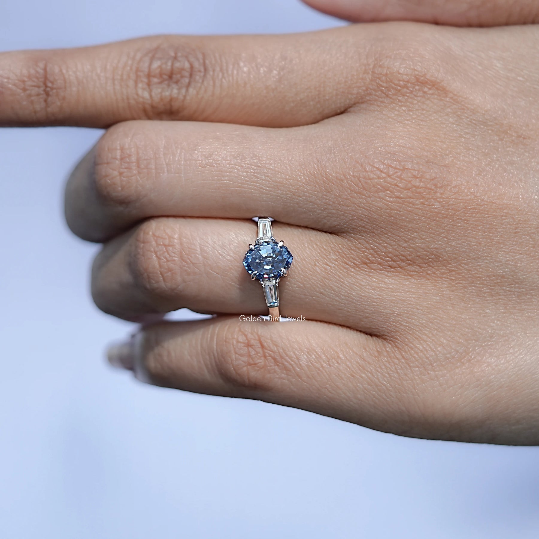 In finger front view of Oval shape moissanite wedding ring in unique shape
