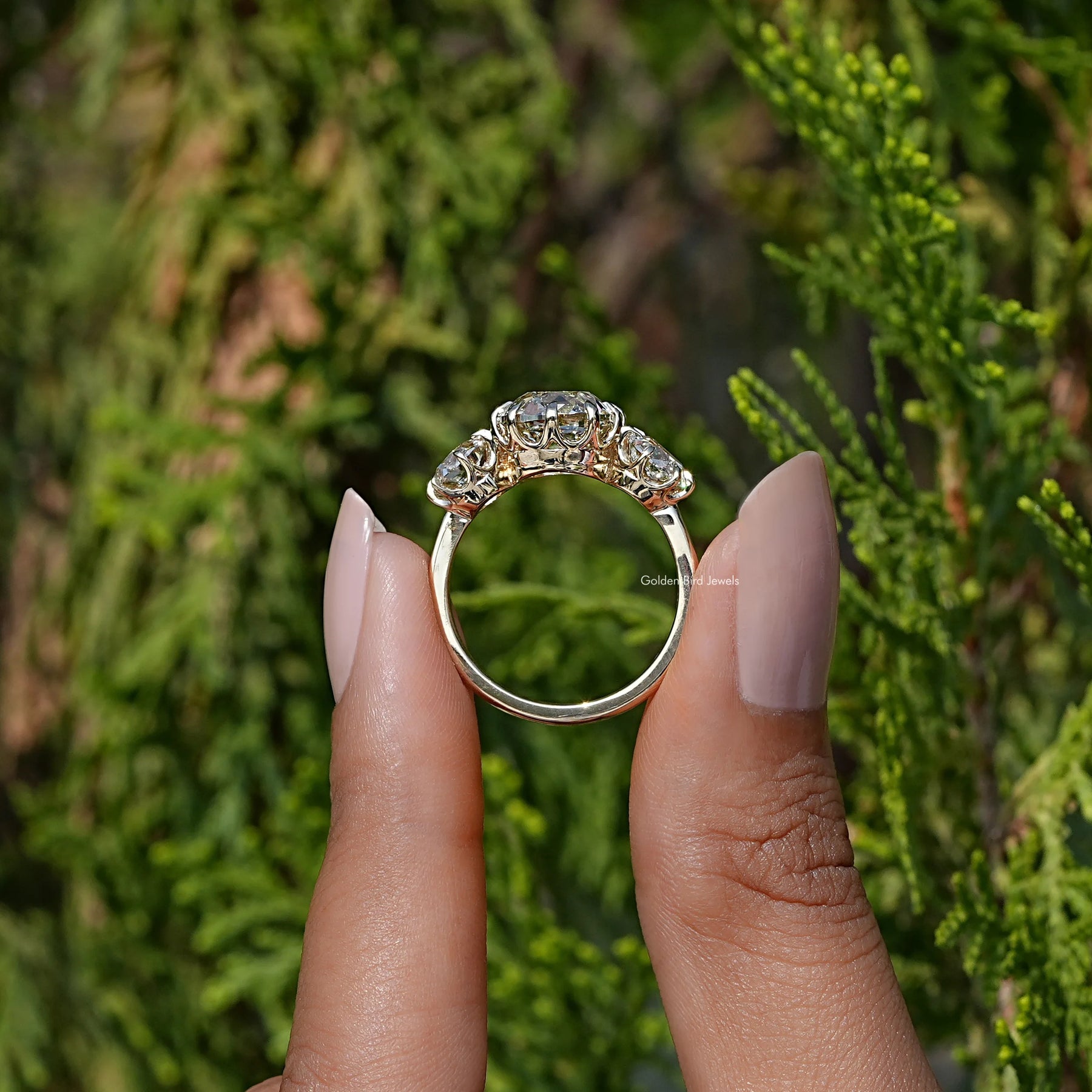 Back View of Old Mine Cushion Diamond Three Stone Ring In two fingers