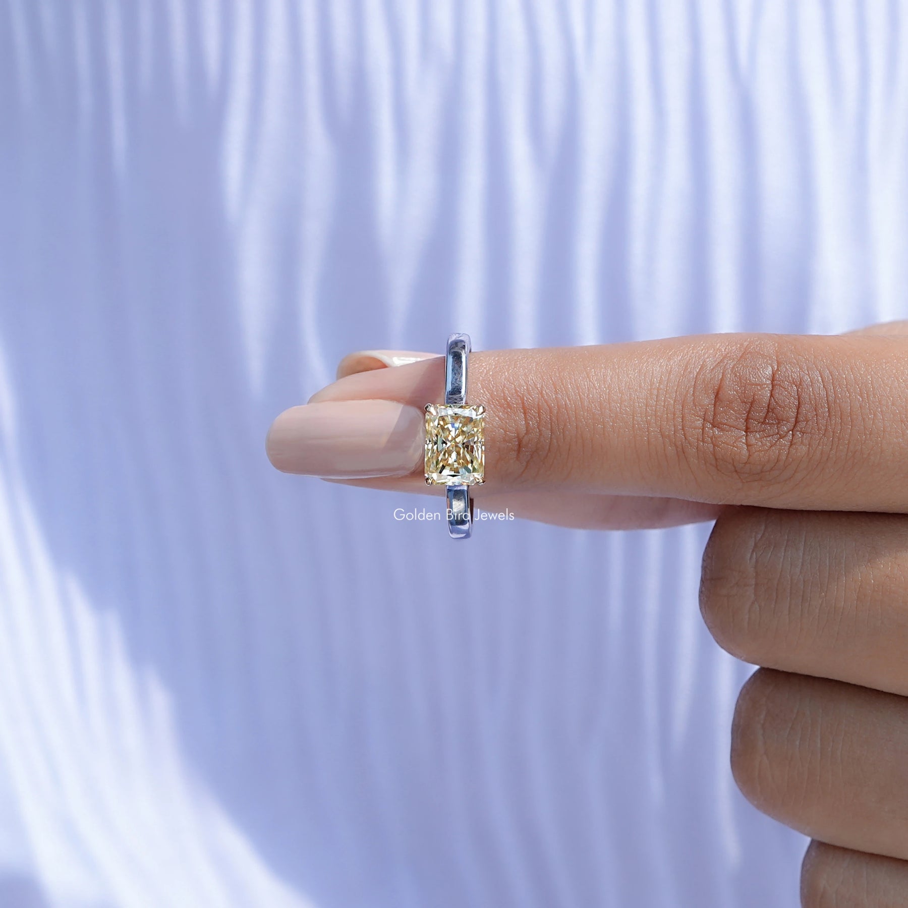 In finger front view of East West Yellow Radiant moissanite Solitaire Ring in unique shape