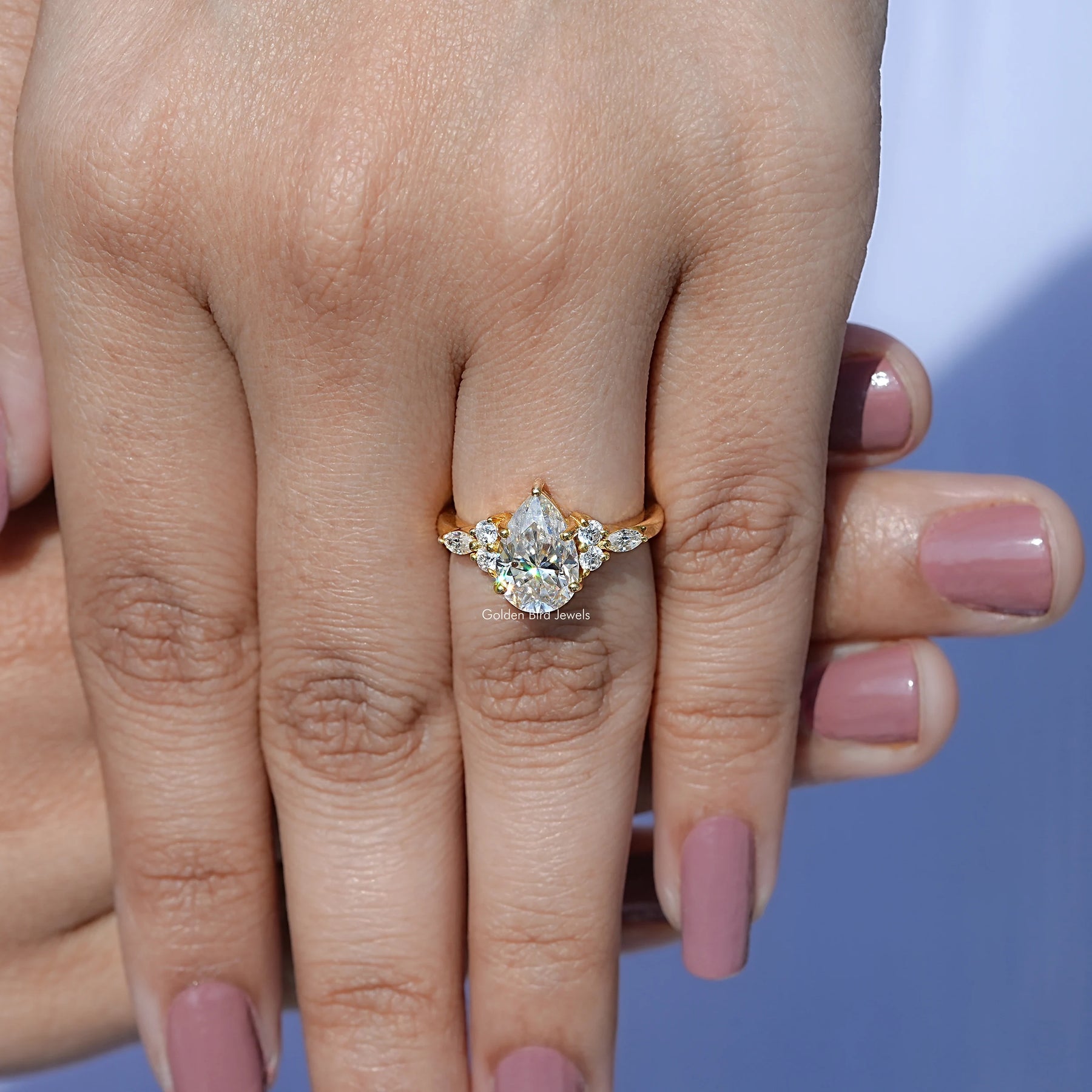 In finger front view of Pear cut moissanite Accent engagement ring in unique shape