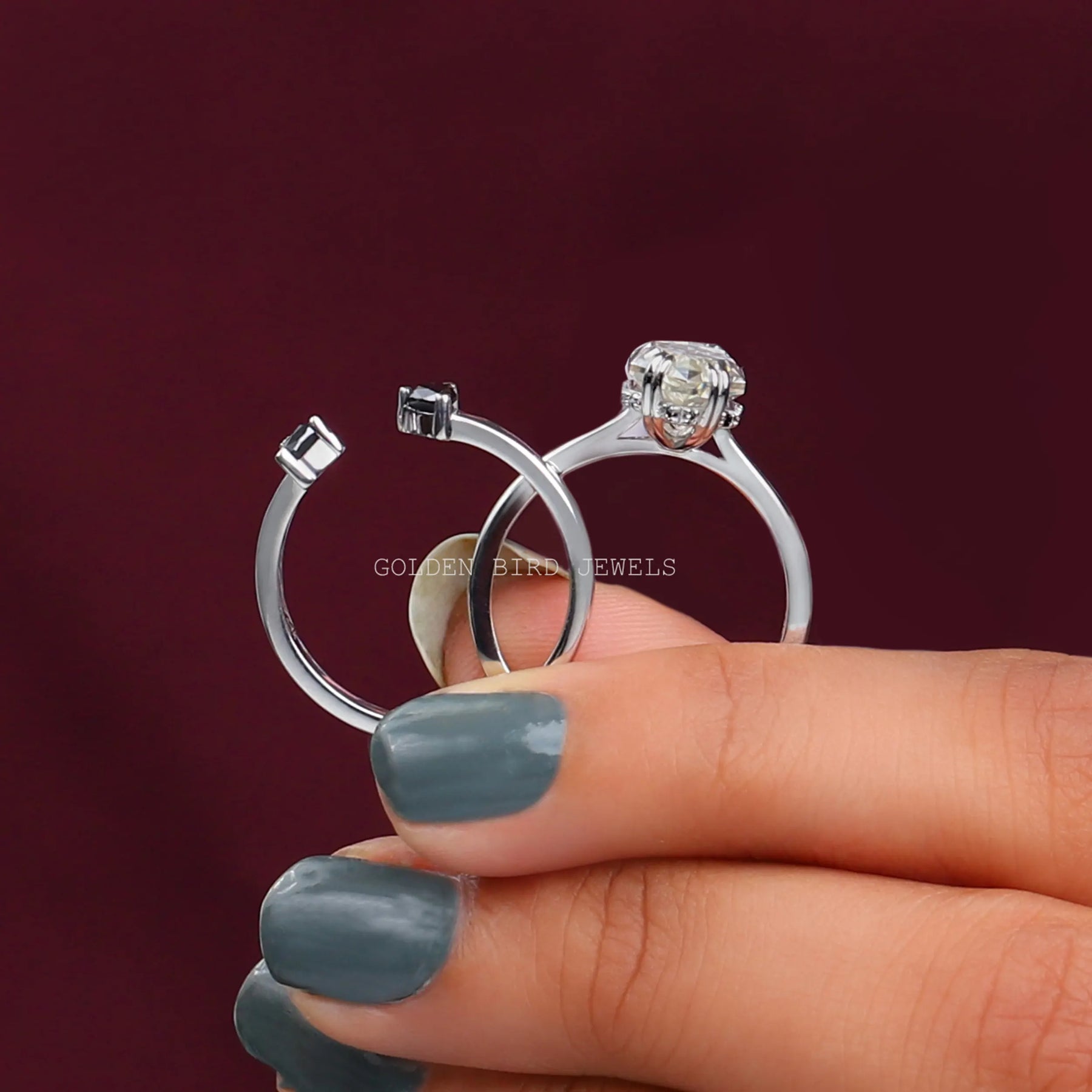 Two fingers holding the Dutch Marquise Hidden Halo Trillion Ring