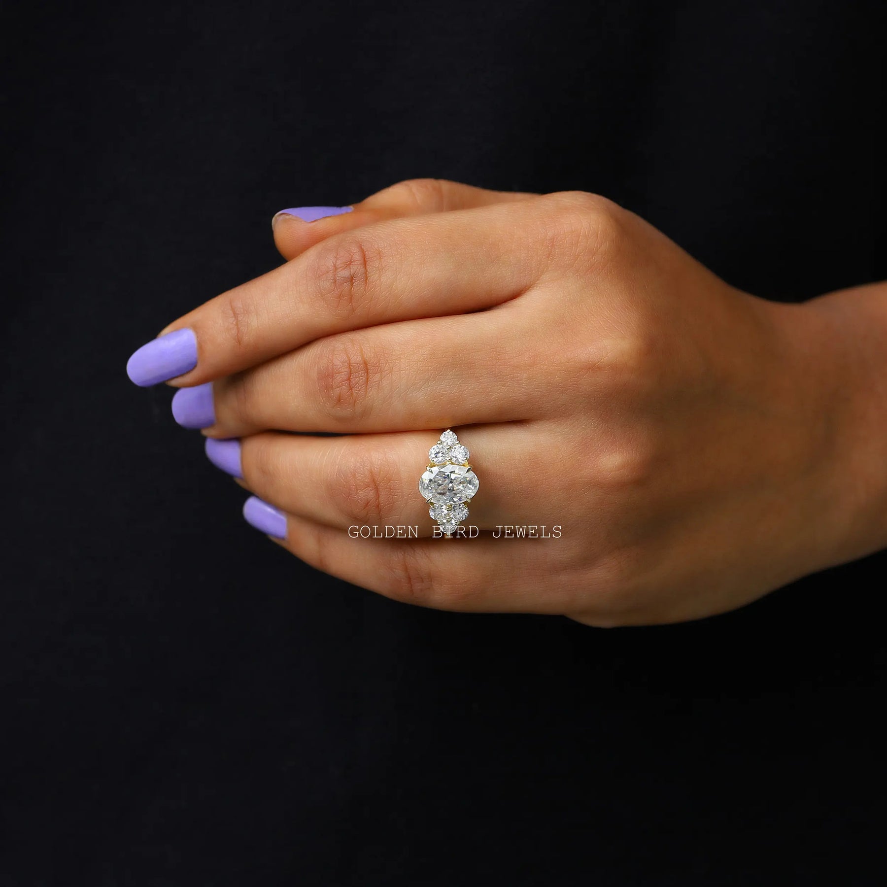 In finger front view of an oval moissanite engagement ring