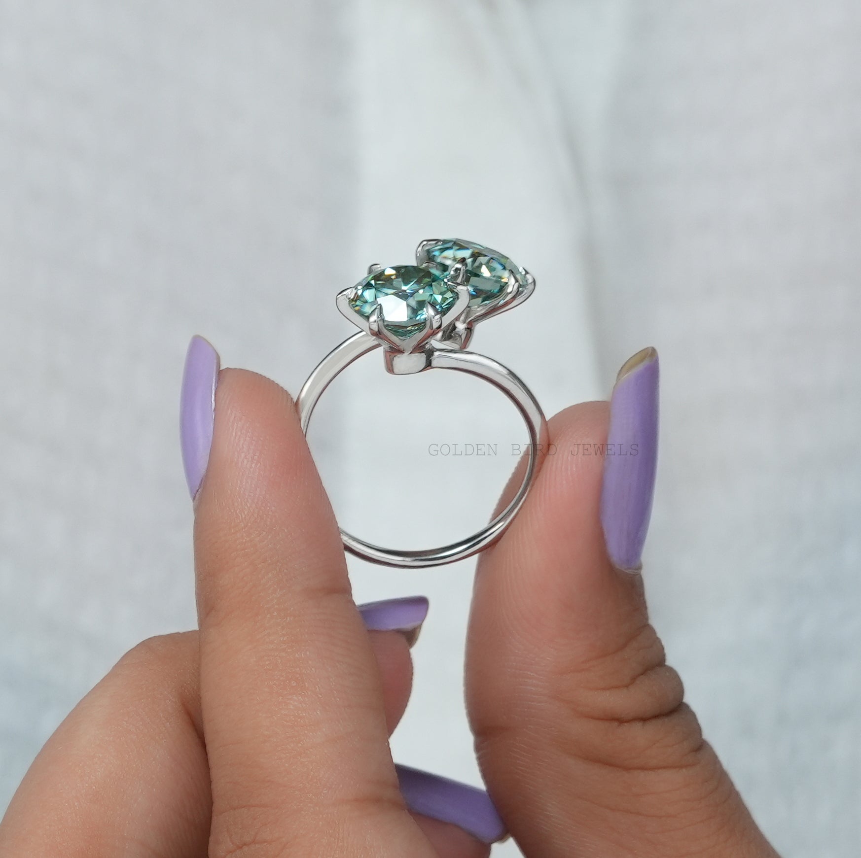 side view of a solitaire blue round cut moissanite ring for women