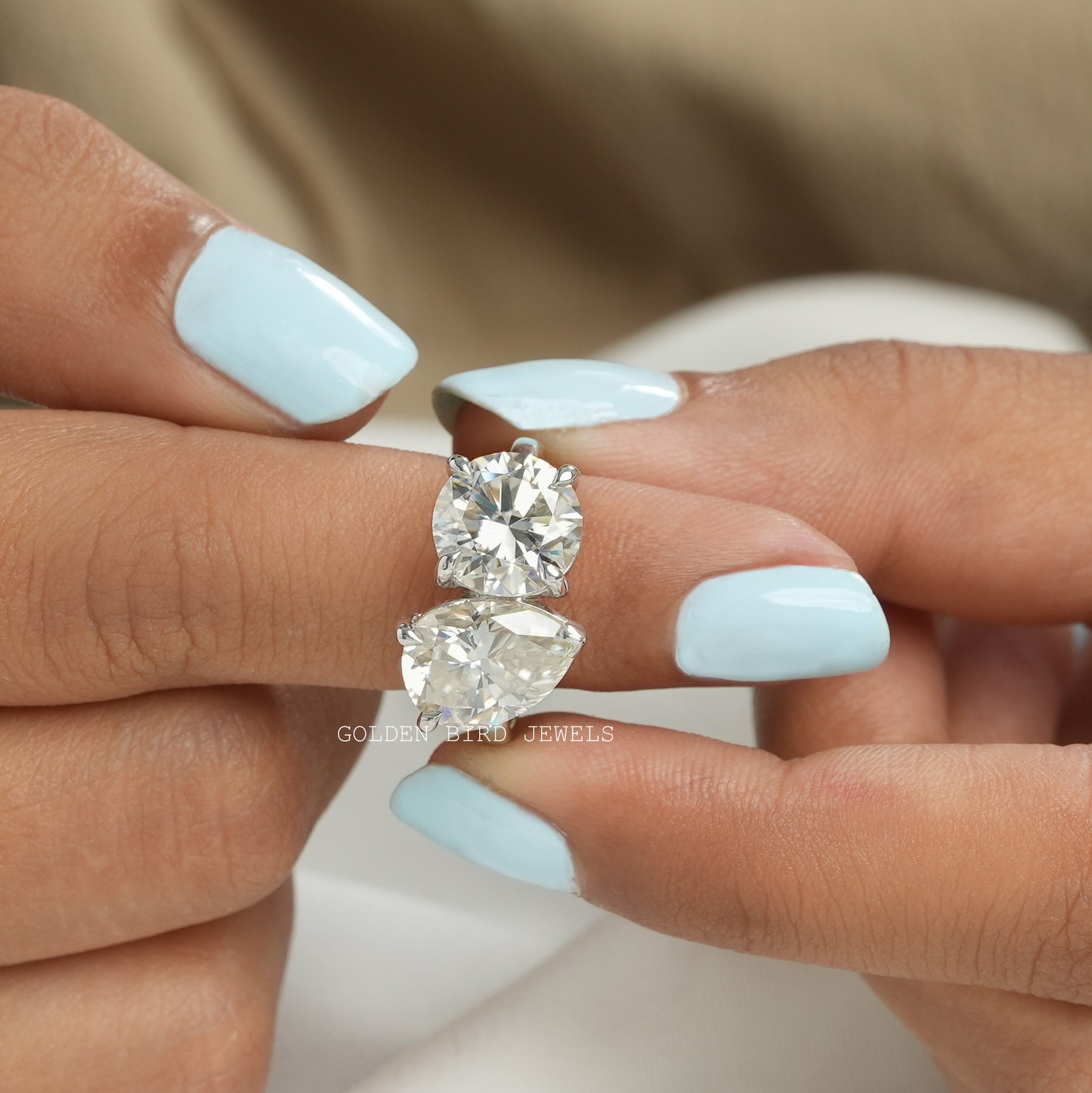 In finger front View of Pear And Round Cut Moissanite Toi Et Moi Ring In White Gold