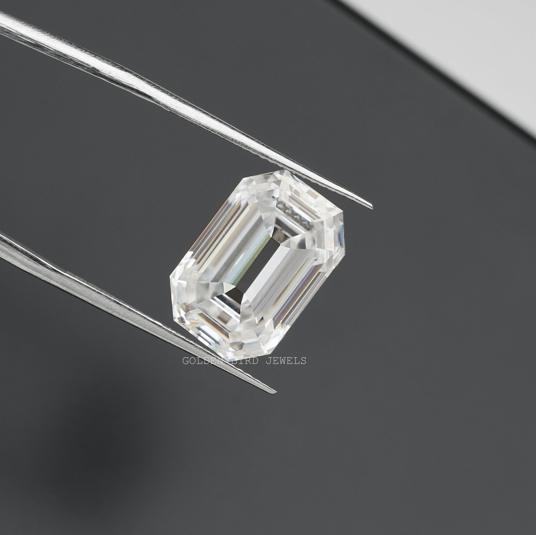 Tweezer view of Old Mine Emerald Cut Loose moissanite