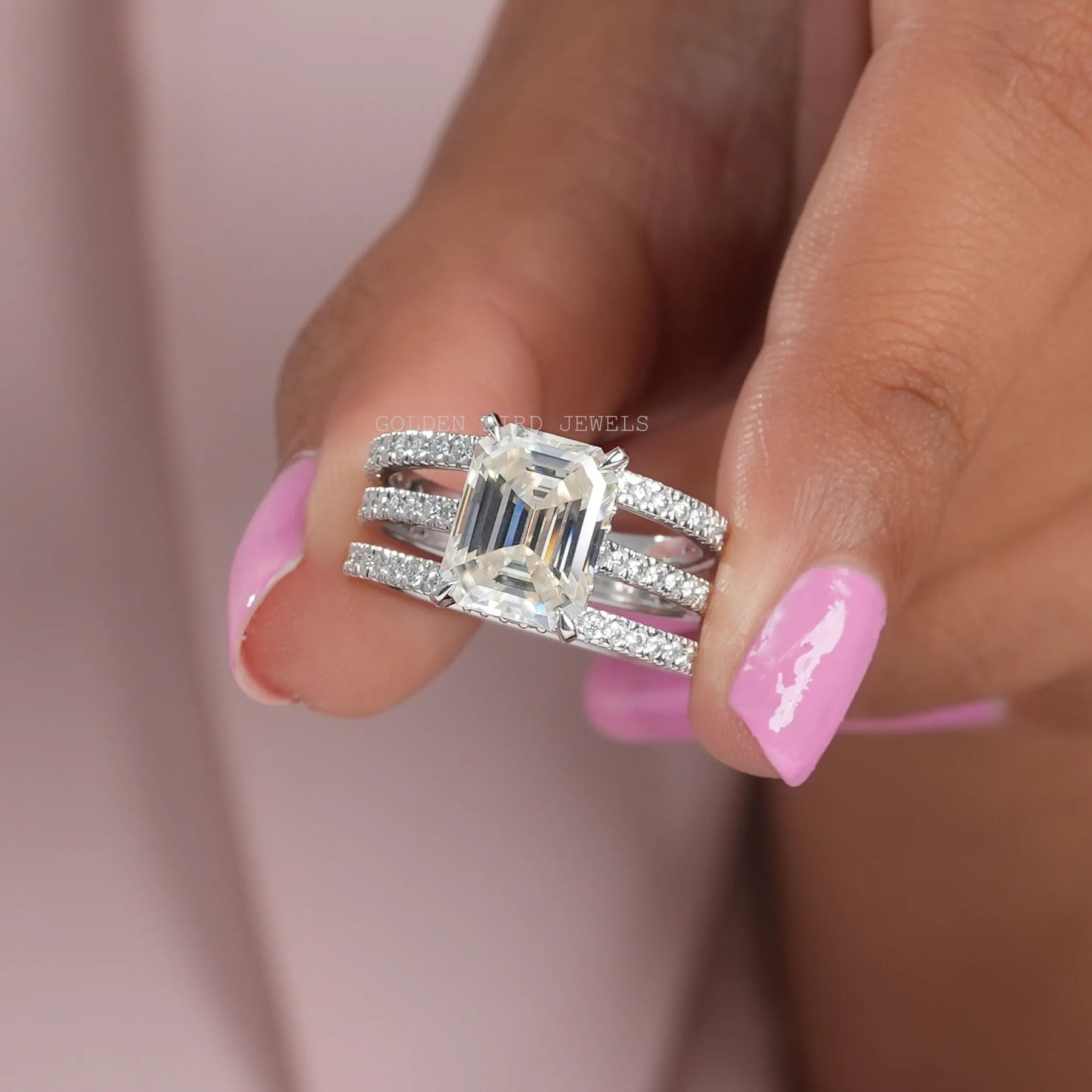 Front View of Emerald Cut Moissanite Ring With Two Matching Bands In two Fingers