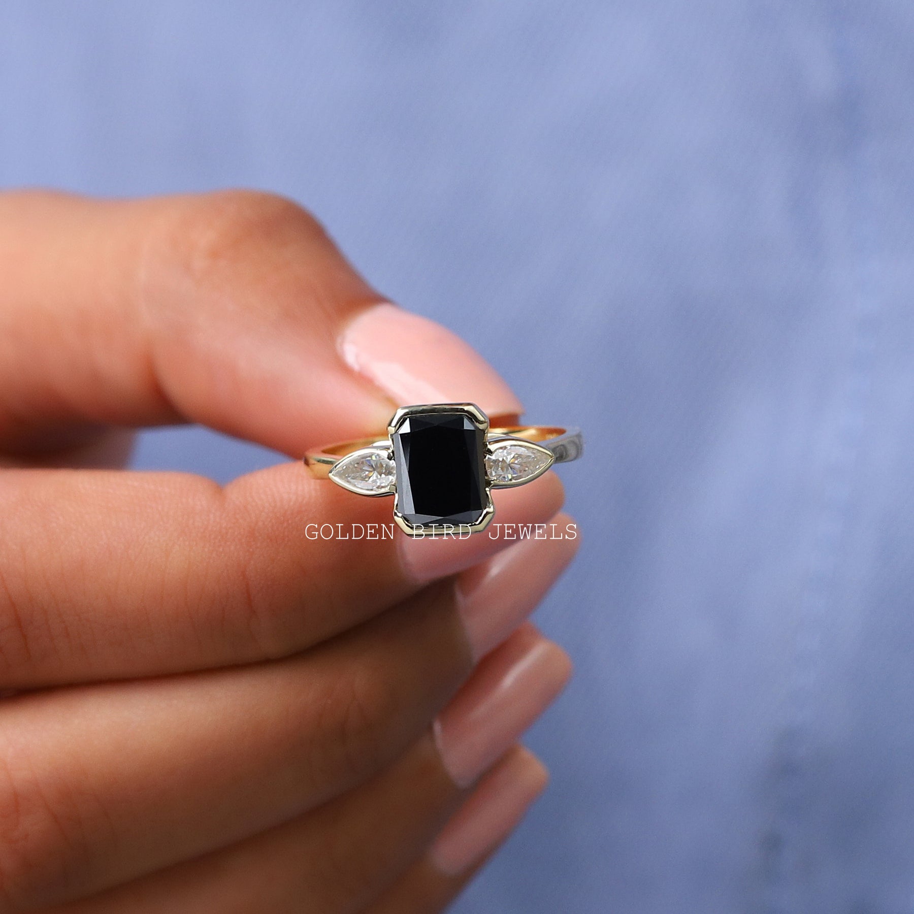 In finger front view of three stone moissanite engagement ring