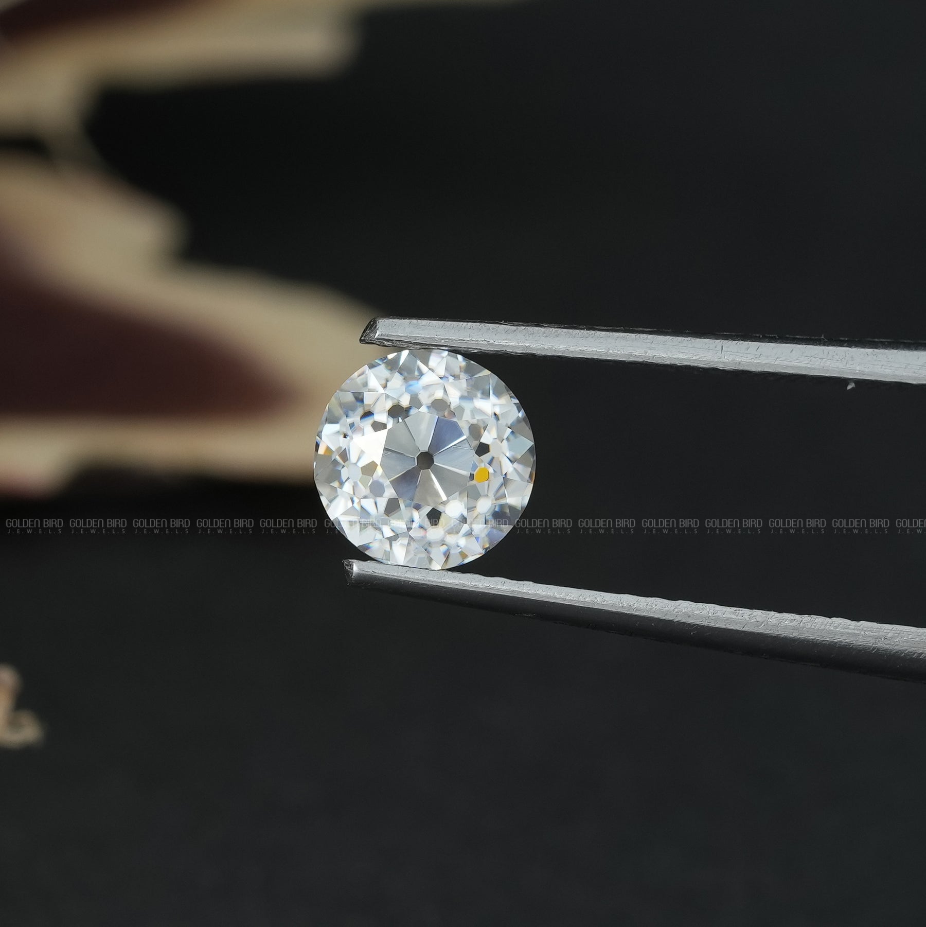 Tweezer view of Old European Round Cut Moissanite Stone