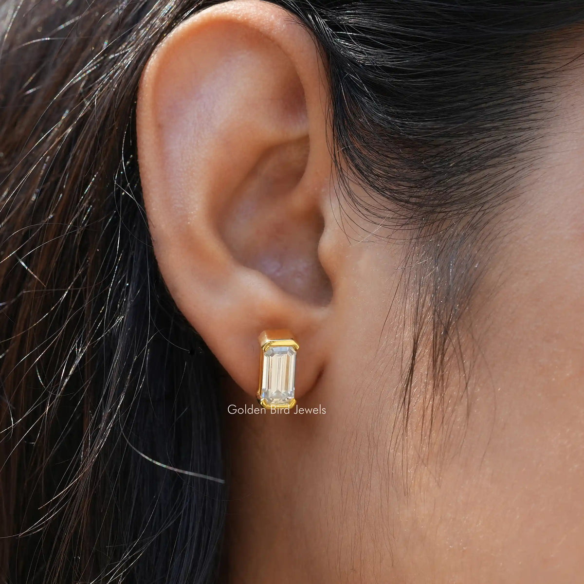 In ear front view of emerald cut stud earrings