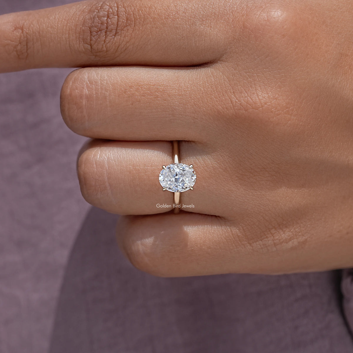 Close-up oval moissanite ring with crushed-ice center and four prongs