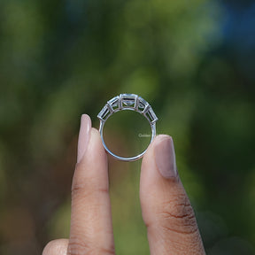Back View of Asscher Cut Tapered Baguette Accent Five Stone Ring In two fingers