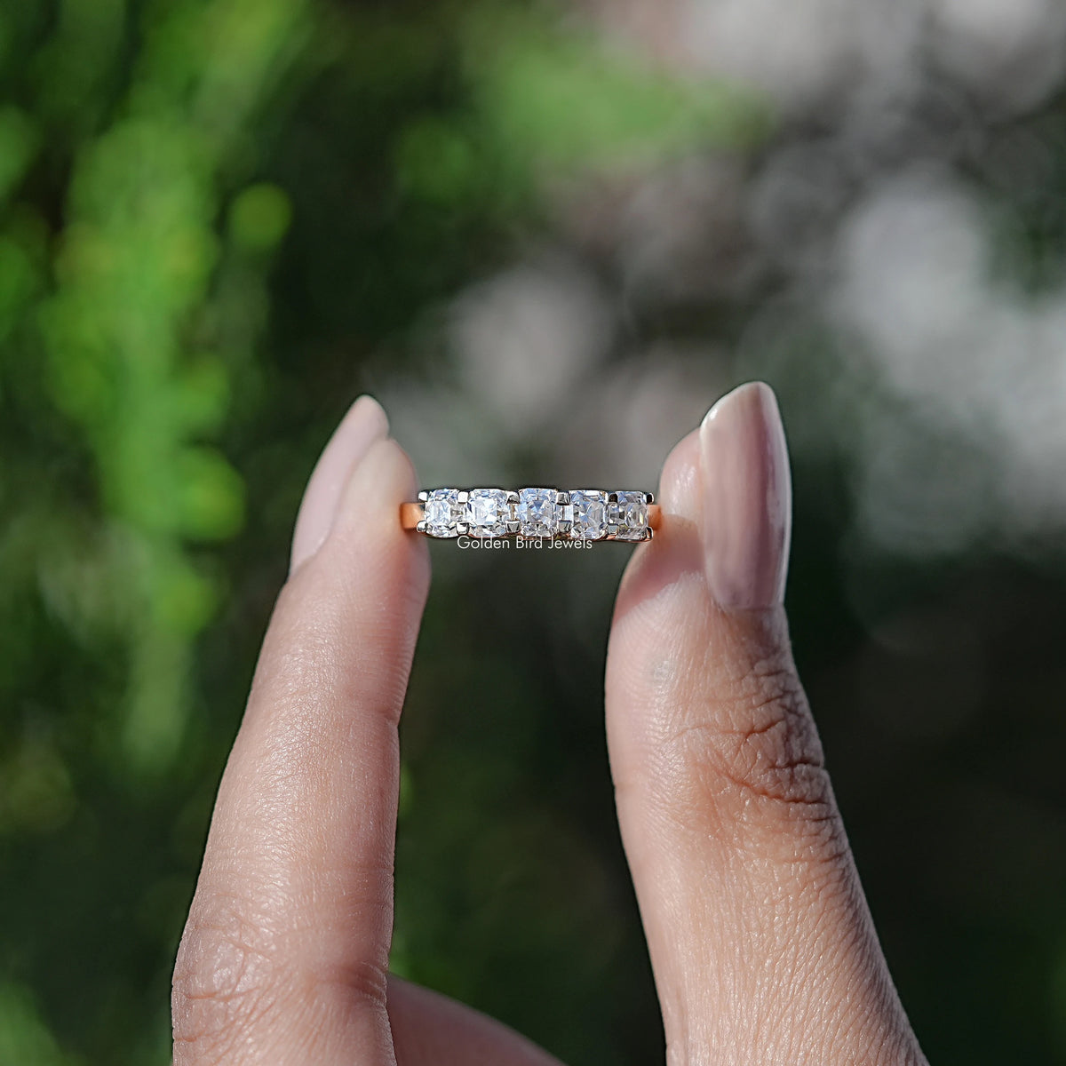 Front view of Asscher Cut Moissanite Five Stone Wedding Band in two fingers 