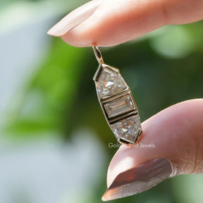 Holding hand view of baguette and pendant cut pendant 