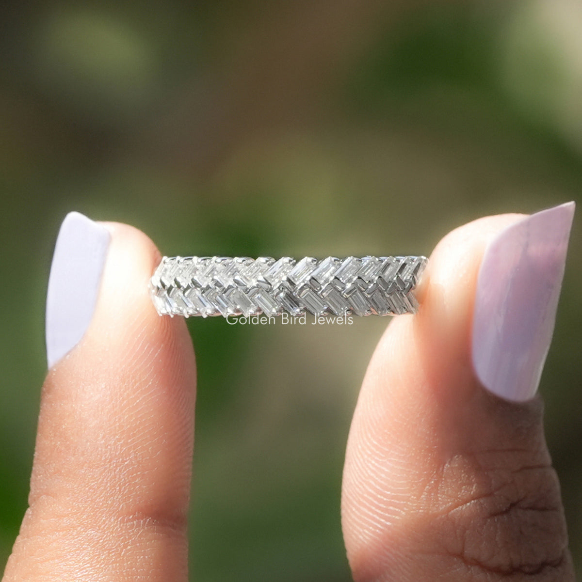 Two fingers holding the Baguette Cut Moissanite Wedding Band
