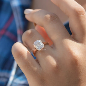Detailed View Of Bezel Set Emerald Cut Moissanite Ring In Yellow Gold