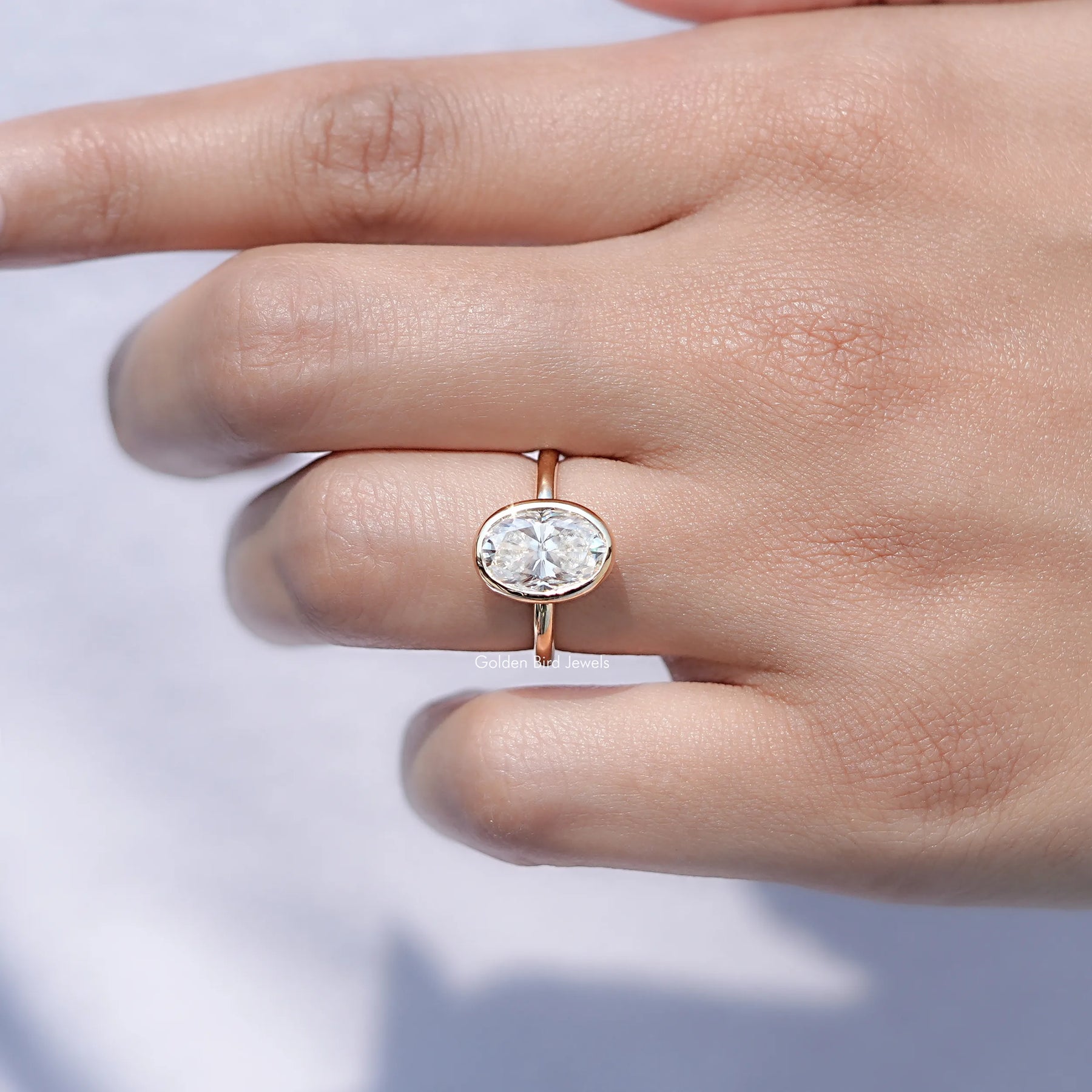 In finger front view of Oval Moissanite Halo Engagement Ring in unique shape
