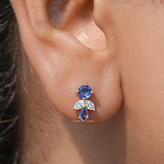 Blue lab diamond cluster stud earrings with round blue center and small clear accents
