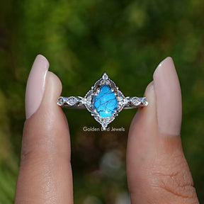 Front View of Blue Turquoise Pear Gemstone Accent Ring In two Fingers