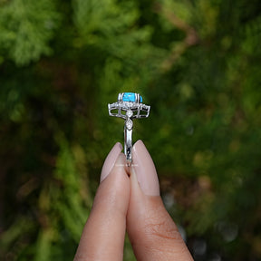 Side View of Pear Cut Gemstone Accent Set Ring In two fingers