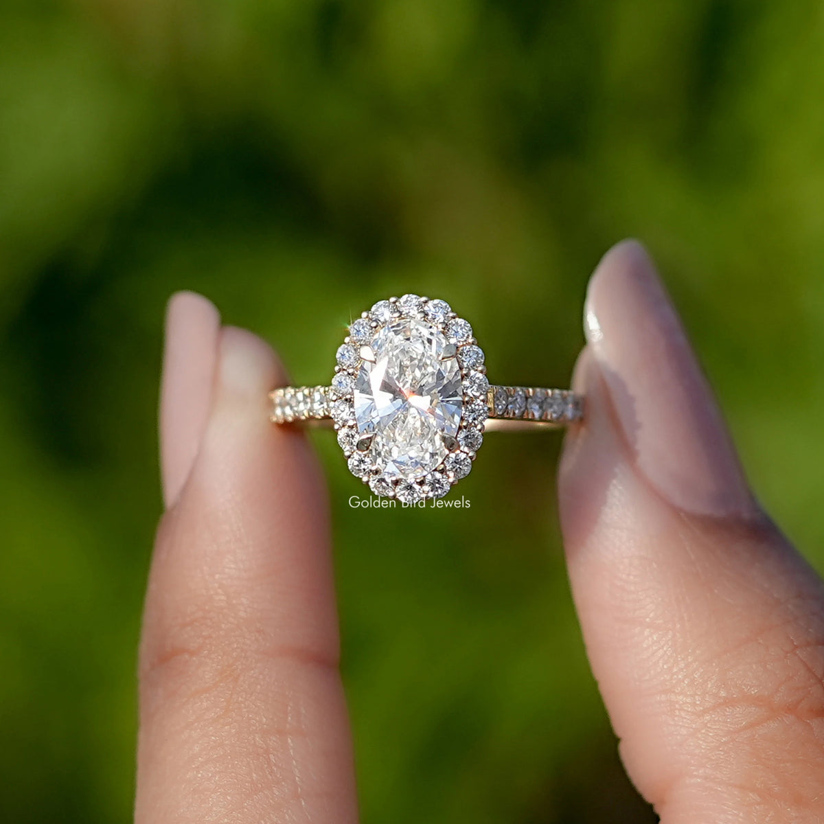 Front View of Oval Cut Lab Diamond Halo Engagement Ring In two Fingers