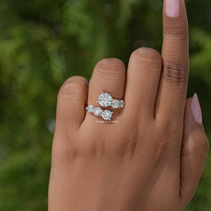 Round-cut bypass ring with three clustered stones on a slim band