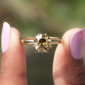 Two fingers holding the Old European Round Cut Solitaire Ring 