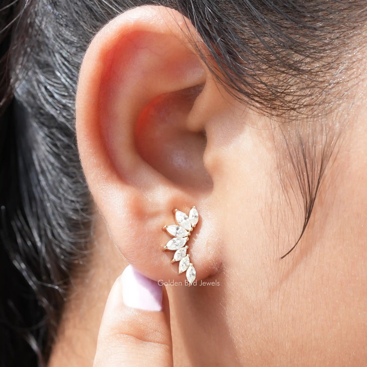 In ear front view of colorless marquise moissanite stud earrings