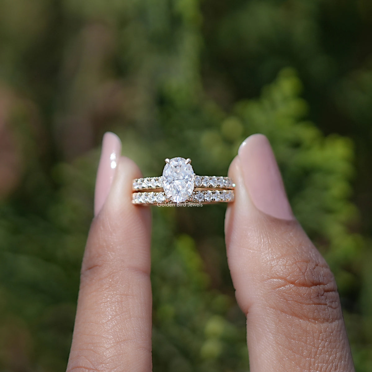 Front view of Crushed Ice Oval moissanite engagement ring holding in two fingers 
