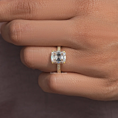 Cushion-cut solitaire moissanite ring with gold-tone prongs and pave band detail