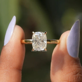 Two fingers holding the Cushion Crushed Ice Moissanite Ring