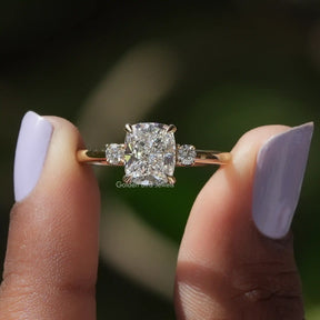 Cushion Cut Diamond Three Stone Ring held between two fingers