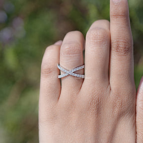 In finger front view of cross over Round Moissanite engagement ring 

