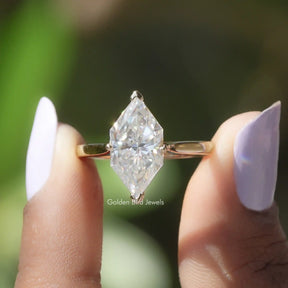 Two fingers holding the Dutch Marquise Yellow Gold Moissanite Ring