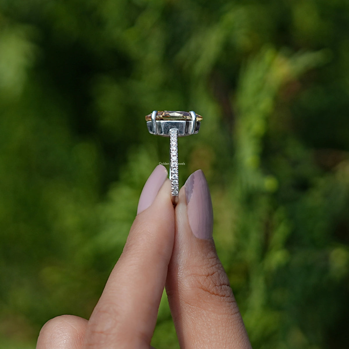 Side view of moissanite ring holding on two fingers 