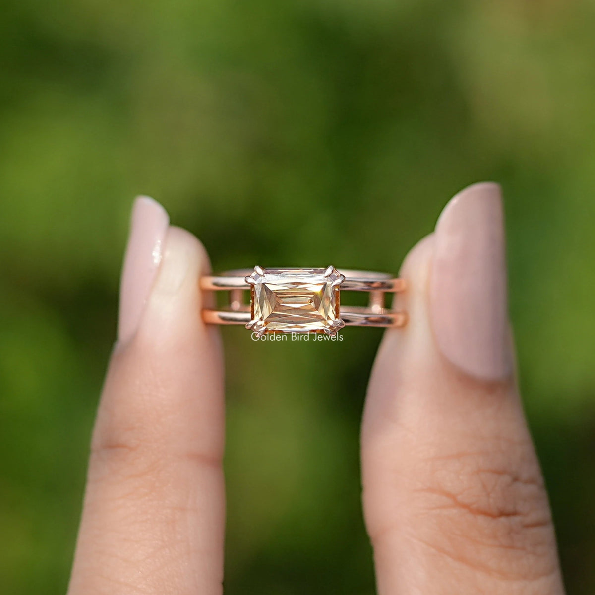 Front view of East West Criss Cut moissanite engagement ring holding in two fingers 