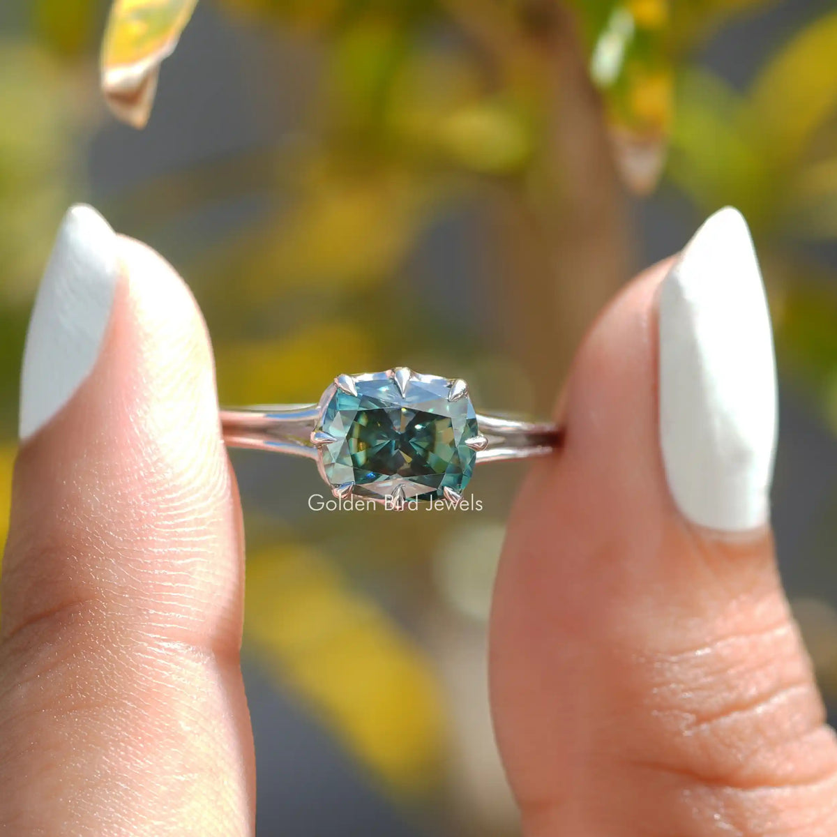 Two fingers holding the Cushion Cut Moissanite Solitaire Ring