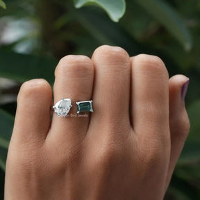 Emerald and pear-cut moissanite  ring in a secure setting 