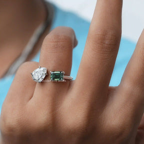 In finger front view of an emerald cut and pear-shaped Moissanite  ring 