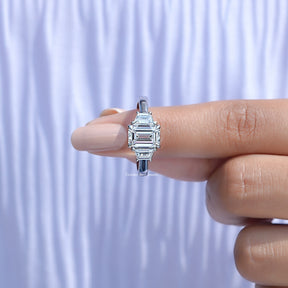 In finger front View of Emerald And Tapered Baguette Cut Diamond Three Stone Ring In Yellow Gold