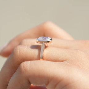 Side View of Moissanite Emerald Cut Bezel Set Ring In two finger