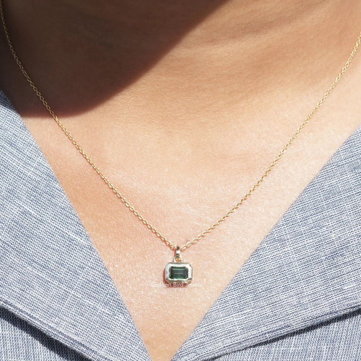 View of green emerald cut moissanite pendant 