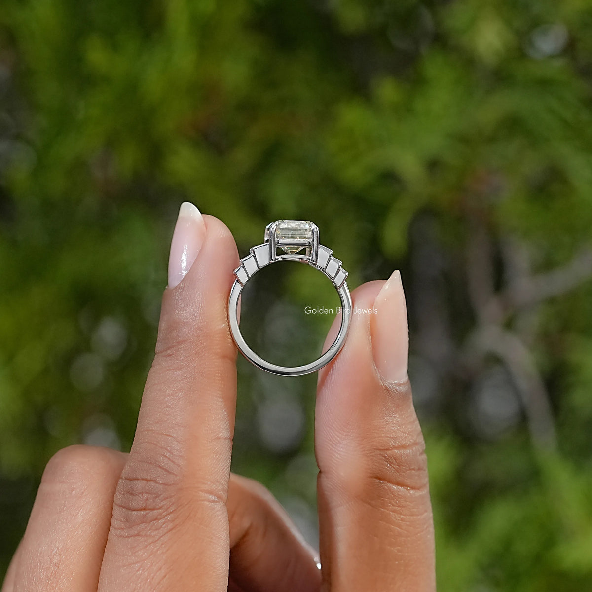 Sterling silver ring viewed from the side, showing the elevated center stone and baguette accents