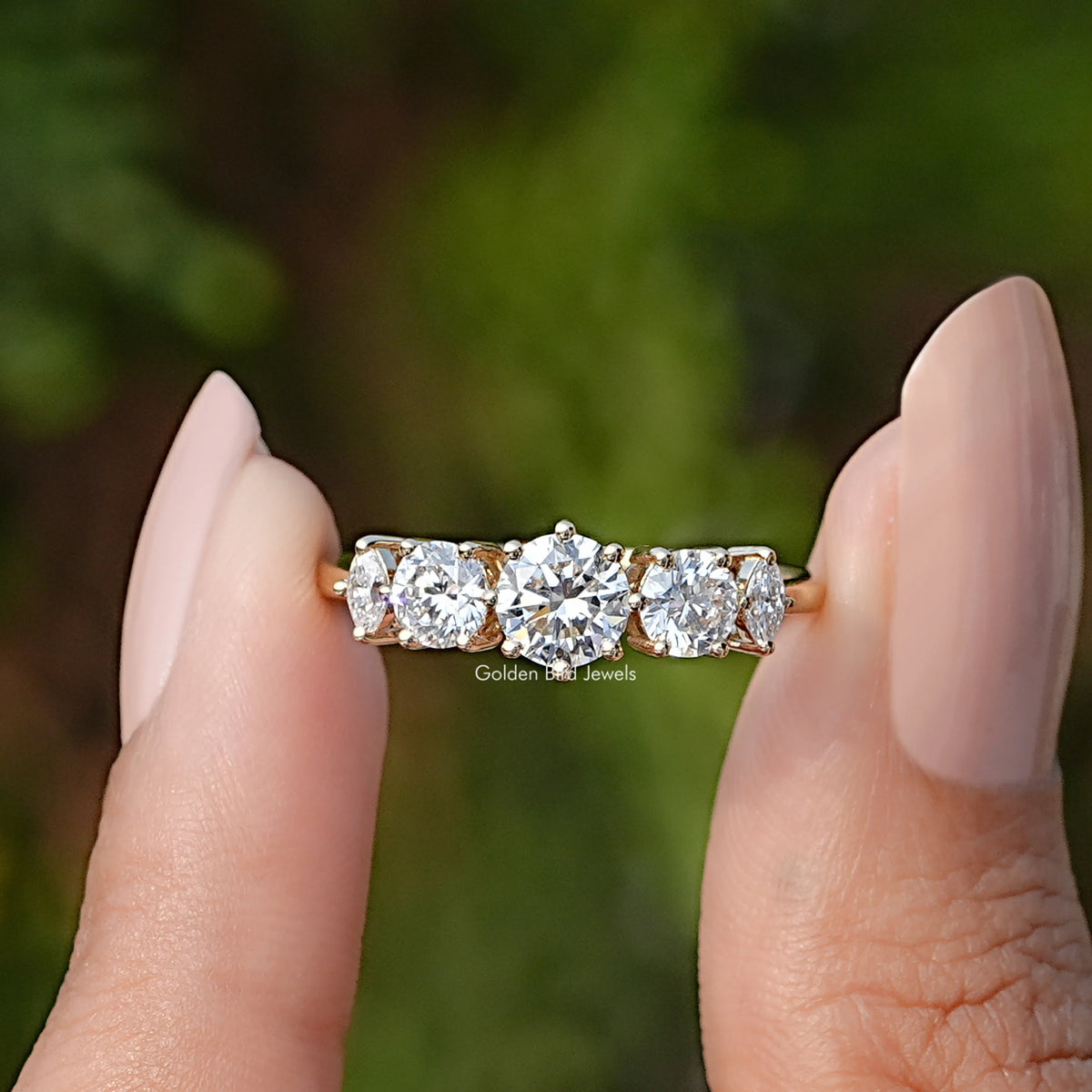 Two fingers holding the Round Cut Lab Diamond Five Stone Ring
