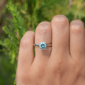In finger front view of  Blue Green Round moissanite Solitaire Ring 
