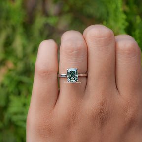 In finger front view of Fancy Green Elongated cushion moissanite hidden halo ring 