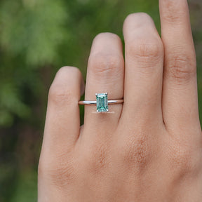 In finger front view of Green Emerald Cut Moissanite engagement ring 
