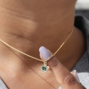 Side view of green emerald pendant In yellow Gold